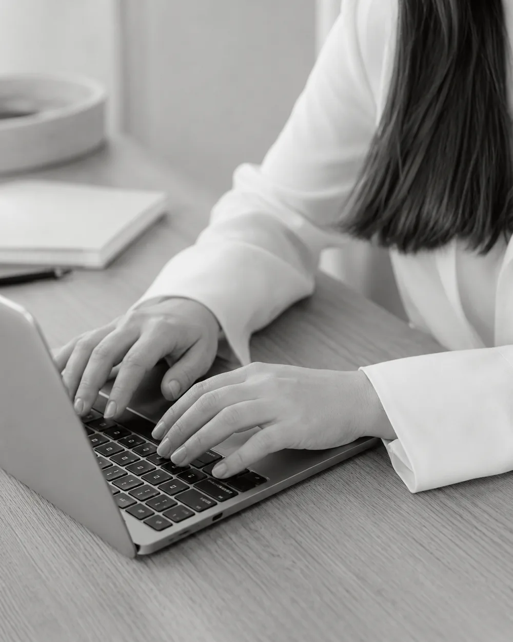 Hände tippen auf einem Laptop – konzentriertes Arbeiten am Master-Briefing